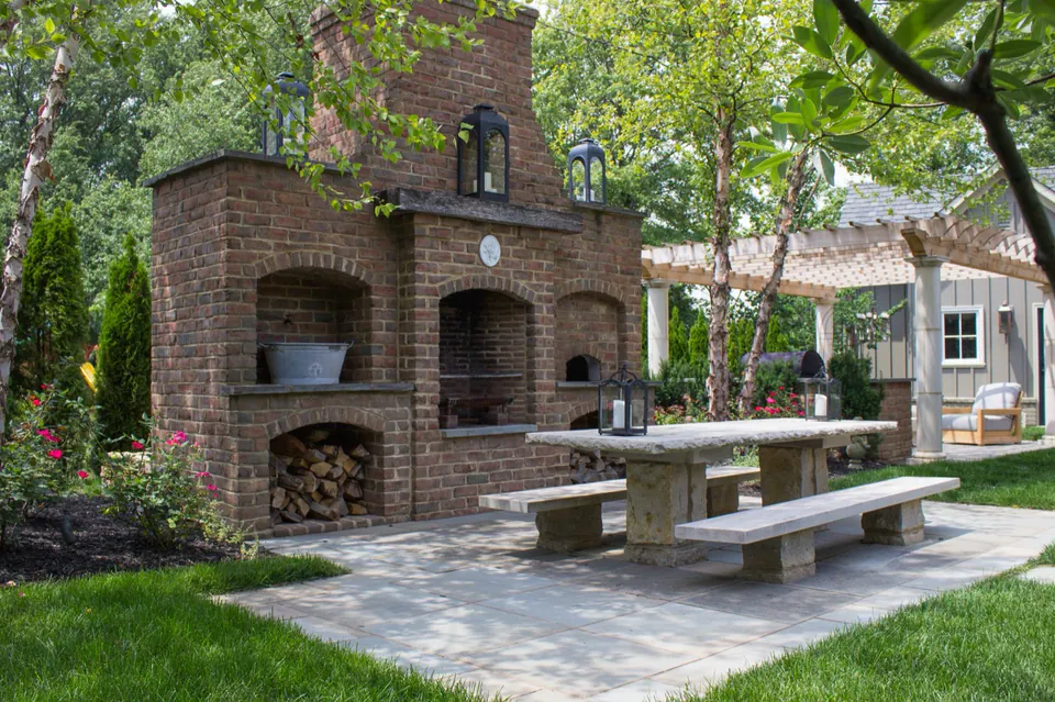 Brick outdoor fireplace with stone patio and garden seating